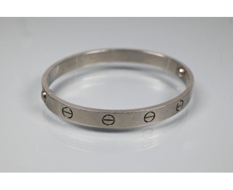 Cartier - an oval 'love' bangle, white metal stamped 750, etched Cartier inscription numbered M.16532, no 17, ©Cartier 1993, 