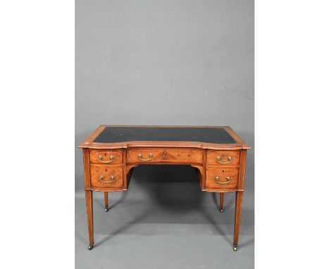A late 19th century cross-banded satinwood desk, the top with leather surface over five drawers, raised on square tapering le