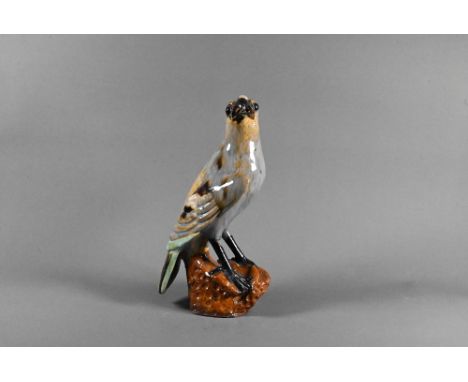 A late 19th or early 20th century Japanese earthenware falcon with variegated purple and brown lead glaze, naturalistically m