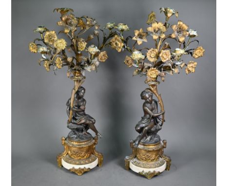 A good pair of French bronze, ormolu and marble six branch candelabra, the seated classical female figures holding aloft flor