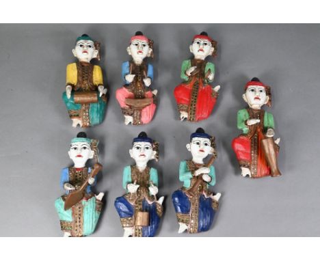 A set of seven vintage polychrome Burmese temple musician wall plaques, carved hardwood with gilded and painted decoration em