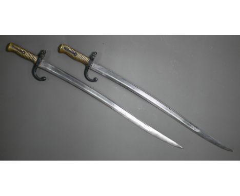 Two 19th century French sabre bayonets, with 57.5 cm curving blades, one marked St Etienne 1869, the other 1868 (no scabbard)