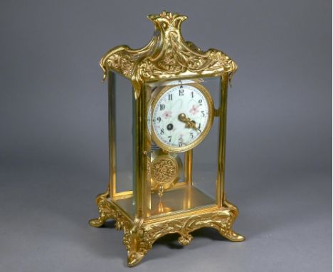 A gilt metal four window mantel clock, the 8-day two train drum movement with white enamelled roman numeral dial, striking th