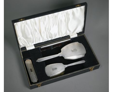 An engine-turned silver four-piece brush set, Birmingham 191961/62, in presentation case  Handle of brush slightly buckled; b