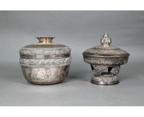 A South East Asian silver stem bowl and cover with lotus bud finial, profusely embossed and engraved with floral scrolls, sta