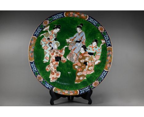 A large late 19th century Japanese porcelain charger, Meiji period (1868-1912) painted in bright polychrome enamels on an eme