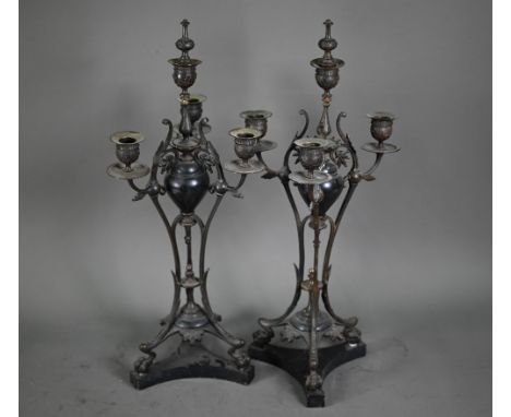 A pair of antique bronze patinated four branch candelabra, on tri-form bases and marble plinths, 54 cm h (2)  