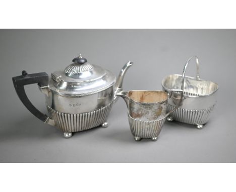 Victorian silver three-piece bachelor tea service of half-fluted oblong form, on later plated bun feet, with composite handle