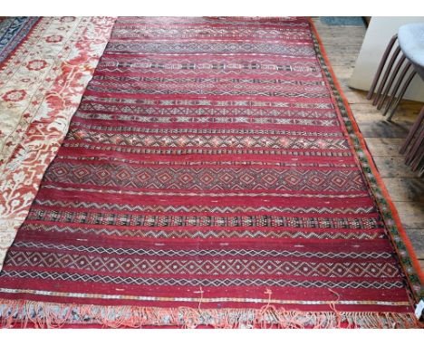 An old Persian Sumak flat weave carpet, the earth red ground&nbsp; with multiple geometric design stripes, 266 x 172 cm  