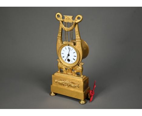 An antique Egyptian Revival ormolu mantel clock, the 8-day drum movement stamped CV 44, with (damaged) white enamel dial, sur