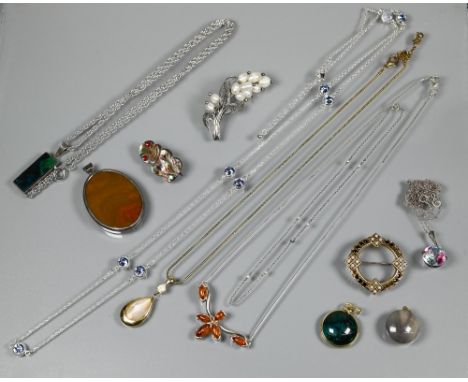 A small collection of costume jewellery including round pendant set possibly tourmaline, mother of pearl set tiki, 1950s simu