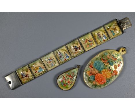 An Indo-Persian mother of pearl pendant painted on one side with polo players, the reverse with flowers and birds, 8.5 cm hig