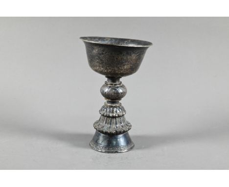 A 19th century Tibetan silver yak butter lamp, the bowl with everted rim richly engraved with leiwen banding and continuous f