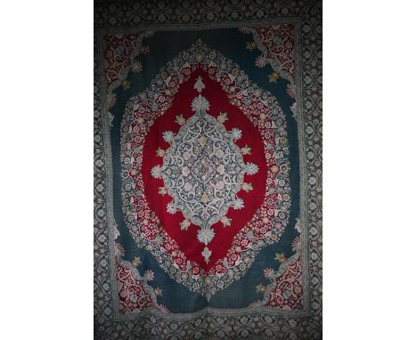 A good and large antique Kashmir crewel work carpet, first quarter 20th century, the soft red ground with stylised floral des