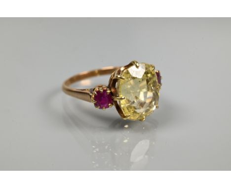 An 18ct yellow gold ring set with central pale yellow stone with ruby to each side, size Q  