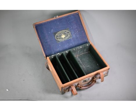 A vintage Harrods cartridge magazine with brass and leather-mounted cloth binding, bears embossed label inside, 47cm wide  tw