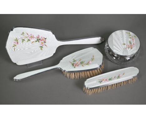 A silver and bas-taille enamel brush set, finely painted with blossoms and&nbsp; comprising two brushes, a cut glass powder b