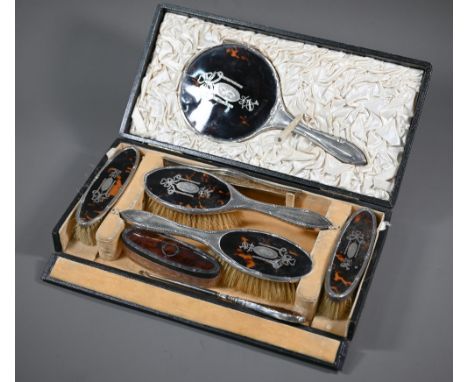 A cased silver and tortoiseshell six piece brush set with pique-work decoration, London 1915, to/w an associated silver-toppe