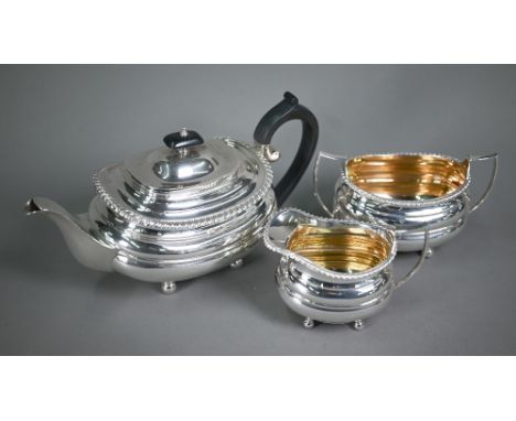 A heavy quality silver three-piece tea service in the Regency manner, of compressed oblong form with gadrooned rims, composit