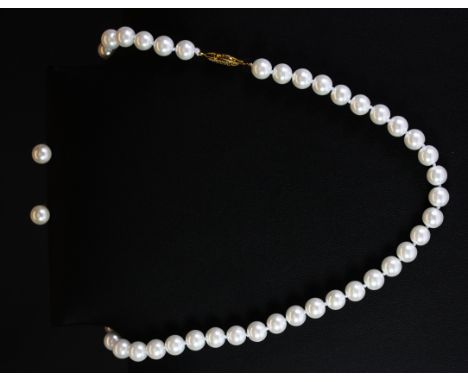 A pearl necklace and a matching pair of pearl earrings.