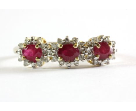 A 9ct yellow gold ruby and diamond set triple cluster ring, (M).