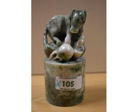 A Chinese variegated green stone seal, carved as a horse and with cylindrical base, measuring 12cm tall