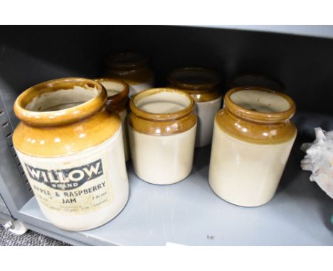 A selection of vintage buff stoneware storage jars, seven in total, the larger retaining the original applied paper label for