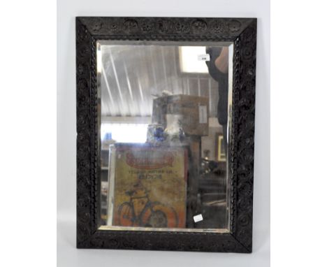 A large early 20th century bevelled edge wall mirror, of rectangular form, with carved hardwood frame, 76cm x 57cm