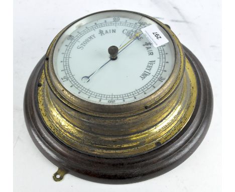 A circular wall barometer, white dial mounted in brass on a wooden plaque, diameter 28cm