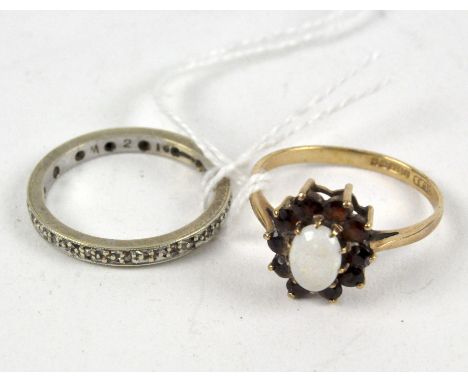 Two ladies 9ct gold rings, comprising; full eternity ring with small claw set white stones and a daisy cluster ring with cent