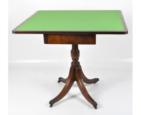 A Regency style Victorian mahogany card table, the folding rounded rectangular top placed above a turned column and sabre leg