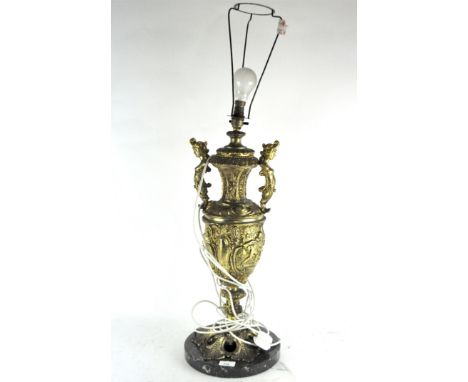 A large gilt ornate table lamp in the form of a twin handled urn, decorated with acanthus leaf motifs throughout, mounted on 