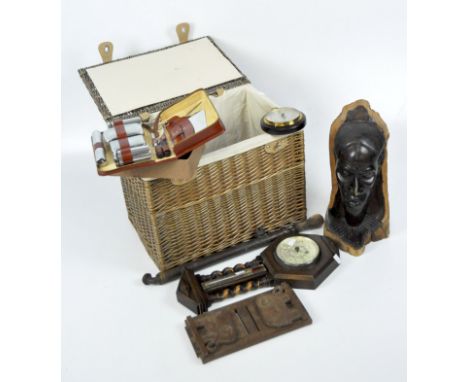 An assortment of collectables, including a barometer, carved wooden head and a wicker basket