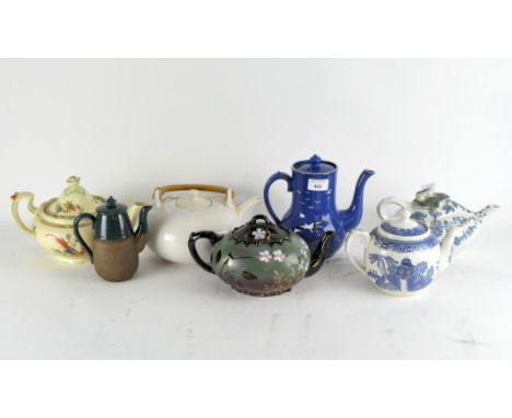 A collection of ceramic teapots including one with Willow pattern, one in the shape of a gourd, one with green, black and gil
