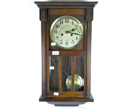 An early/mid-century mahogany wall clock with Arabic numerals to the metal face behind a part bevelled glass door, height 63c