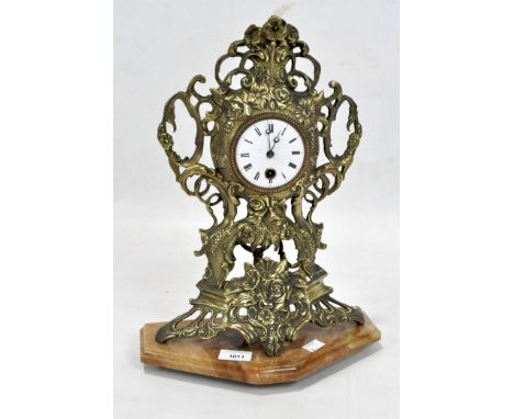A Victorian Rococo style mantle clock, the gilt cast metal frame decorated with flowers and scrolling motifs, white enamel di
