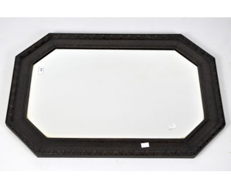 A Victorian bevelled edge octagonal wall mirror, in a mahogany frame with carved details, width 76cm.