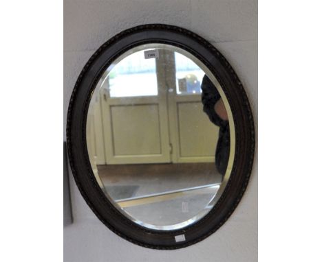 A late 19th/early 20th century bevelled edge wall mirror, of oval form, 60cm x 49cm.