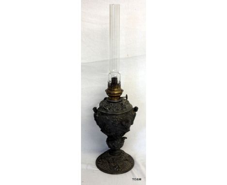 A Victorian cast metal oil lamp with embossed military scene decoration