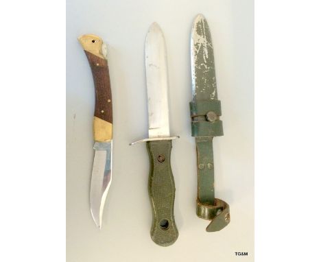 A German Bundeswehr knife in its metal scabbard with leather frog. Marked OFW 69 to the blade and BW to the hilt. With a Span