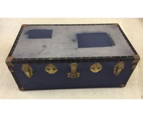 A blue travelling trunk with handles and brass plated fixings 92cm x 51cm approx