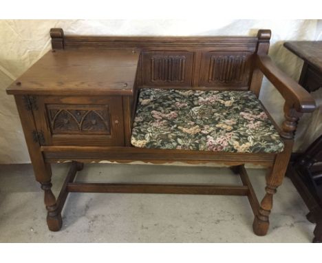 Oak telephone table with linen fold design and tapestry upholstered seat.