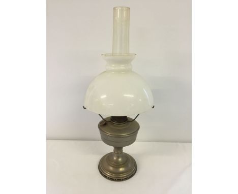 A vintage oil lamp with chimney, shades and mantles