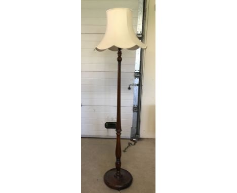 A dark oak decorative standard lamp with a cream shade.