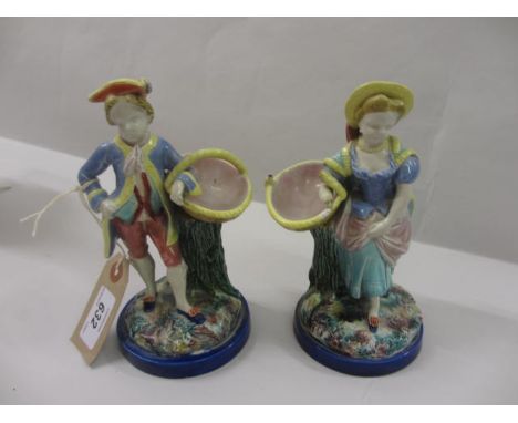 Pair of 19th Century Worcester Majolica figures of a boy and girl, each carrying a basket beside a tree stump (damages to the