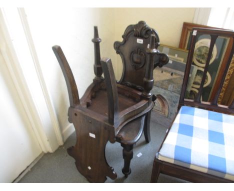 Pair of Victorian carved oak hall chairs with shaped backs and panel seats on turned front supports