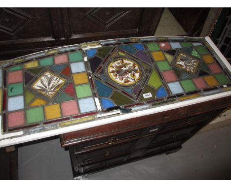 19th Century leaded coloured and three panel stained glass window on stand (a/f), 42ins wide, 17ins high