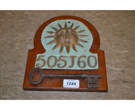 Antique lead Sun Insurance plaque, No. 505J60 mounted on a wooden plaque with an antique iron key