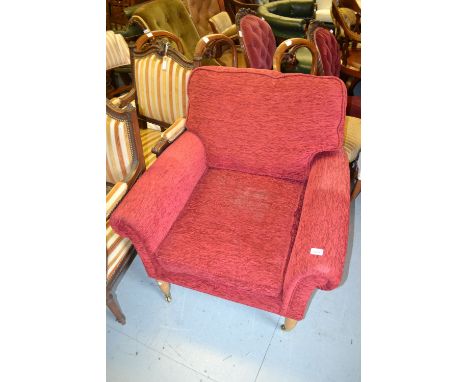 20th Century red upholstered armchair by Peter Guild on turned tapering supports with brass caps and casters