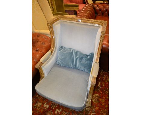 19th Century French carved and gilded armchair with pale blue upholstery, the square form frame decorated with acanthus, scro